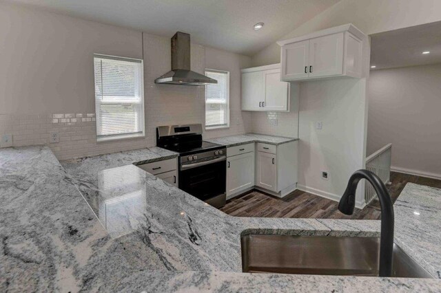 kitchen featuring dark hardwood / wood-style flooring, sink, white cabinetry, electric stove, and wall chimney range hood