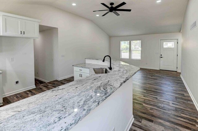 kitchen featuring vaulted ceiling, sink, dark hardwood / wood-style floors, and light stone countertops