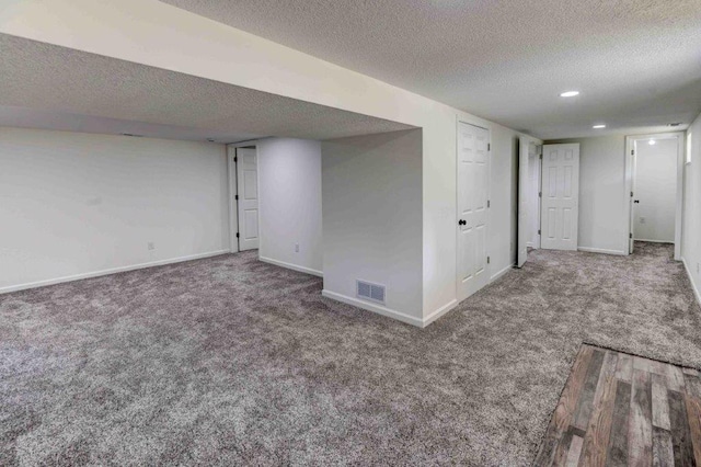 basement with carpet floors and a textured ceiling