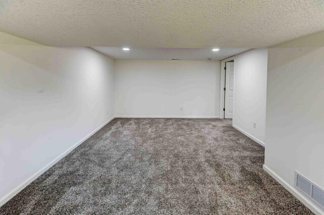 carpeted spare room featuring a textured ceiling