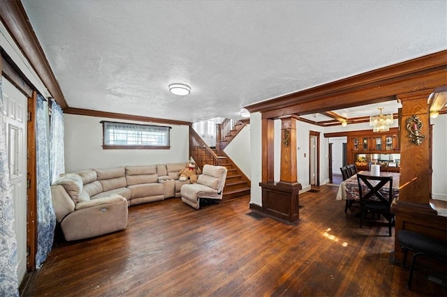 living room featuring an inviting chandelier, a textured ceiling, ornamental molding, and dark hardwood / wood-style flooring