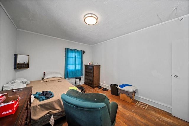 bedroom featuring ornamental molding, a textured ceiling, and hardwood / wood-style floors