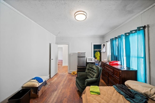 bedroom with hardwood / wood-style flooring, crown molding, and a textured ceiling