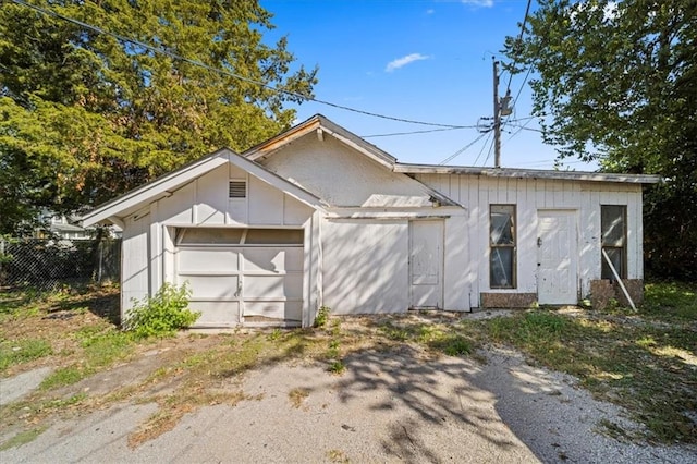 view of front of home with a garage and an outbuilding