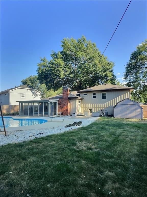 rear view of property featuring a sunroom and a lawn