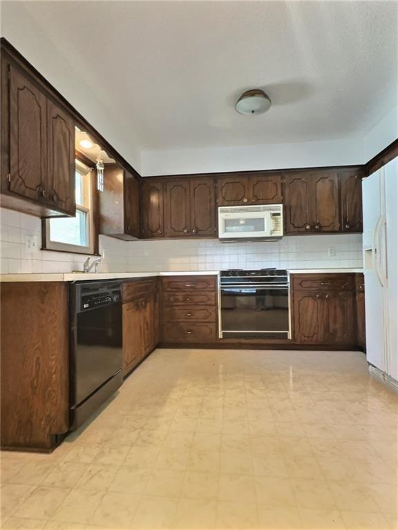 kitchen with black appliances, dark brown cabinetry, and tasteful backsplash