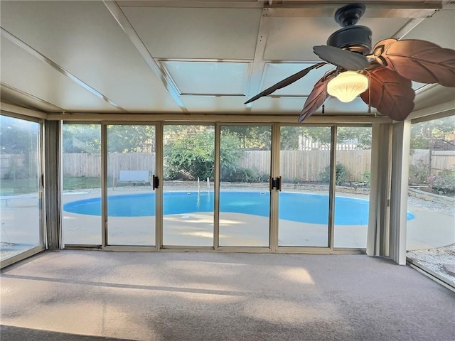 unfurnished sunroom with ceiling fan