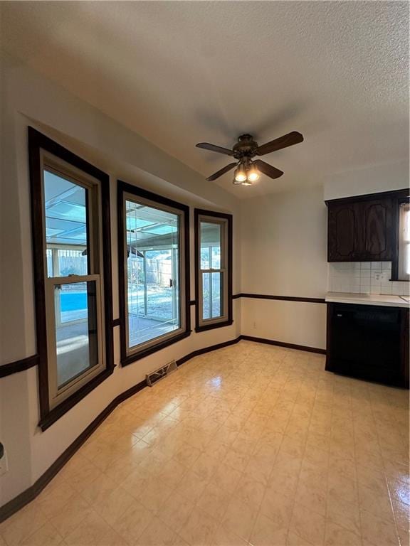 unfurnished living room with ceiling fan and a textured ceiling