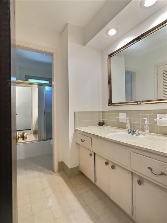 bathroom with vanity and tasteful backsplash