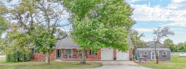 exterior space featuring covered porch, a front yard, and a garage