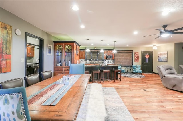 dining area with light wood-style floors, recessed lighting, a ceiling fan, and washer / dryer