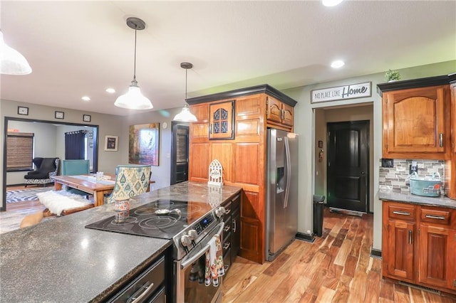 kitchen with decorative backsplash, light wood-style flooring, hanging light fixtures, stainless steel appliances, and recessed lighting