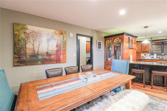 dining room with light wood-style floors, washer / clothes dryer, and recessed lighting