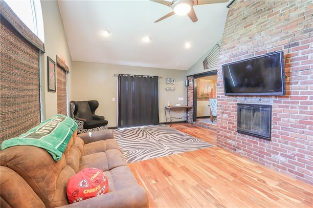 living area featuring a fireplace, recessed lighting, a ceiling fan, wood finished floors, and high vaulted ceiling