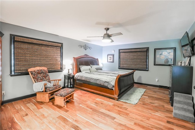 bedroom with a ceiling fan, baseboards, and wood finished floors