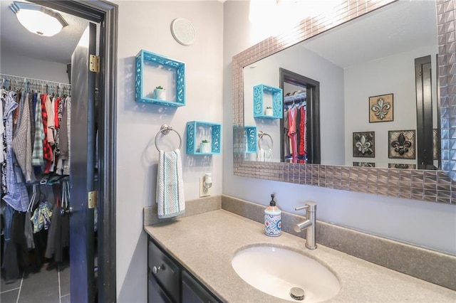 bathroom featuring a walk in closet and vanity