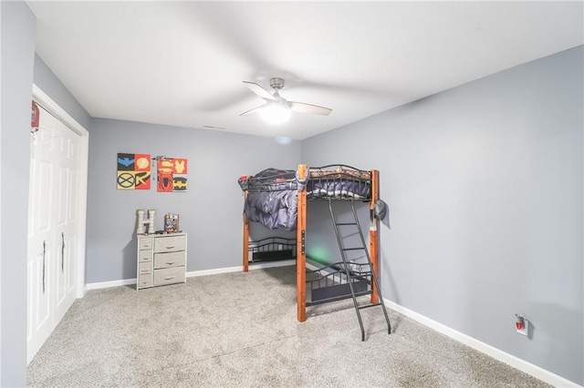 carpeted bedroom with ceiling fan and baseboards