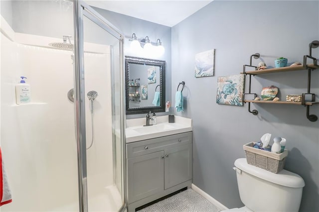 full bath with vanity, a shower stall, toilet, and baseboards