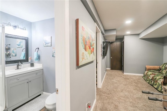 interior space featuring recessed lighting, light colored carpet, a sink, and baseboards