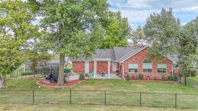 rear view of property featuring a fenced backyard, a lawn, a patio, and brick siding