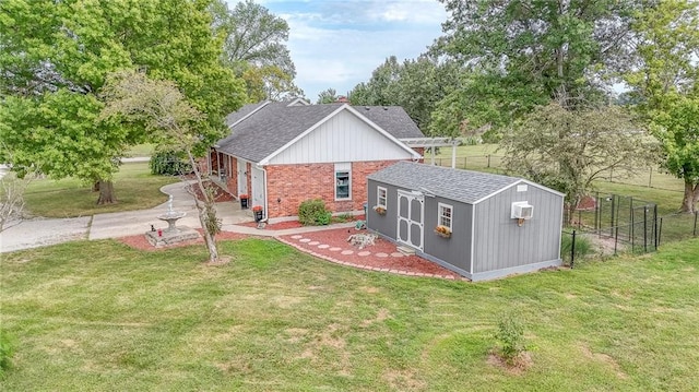 exterior space featuring driveway, roof with shingles, fence, a front lawn, and brick siding