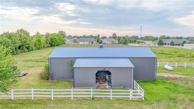 view of pole building featuring a lawn and fence