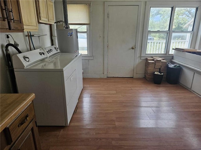 washroom with gas water heater, hardwood / wood-style floors, and washer and clothes dryer