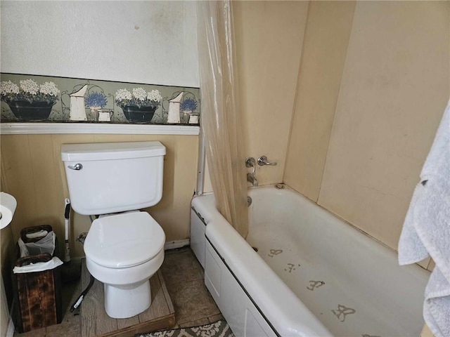 bathroom featuring toilet, shower / tub combo with curtain, and tile patterned floors