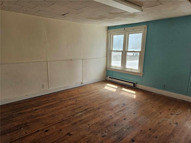 empty room with a baseboard heating unit and hardwood / wood-style floors