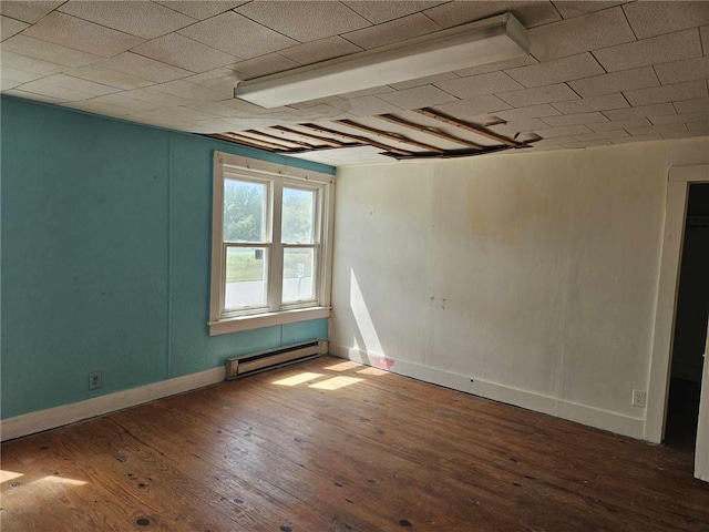 empty room with baseboard heating and wood-type flooring