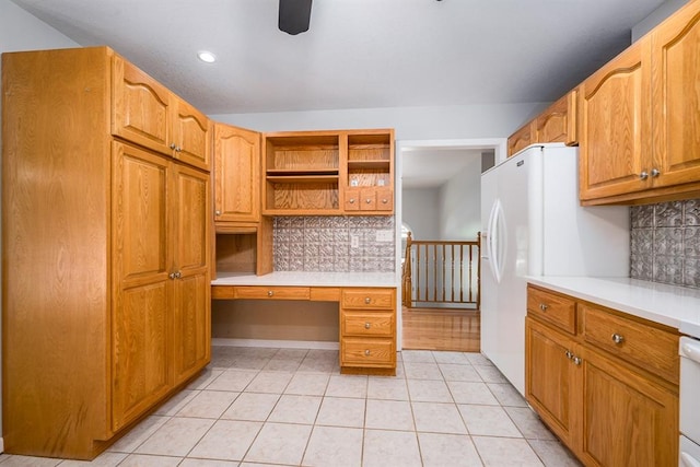 kitchen featuring built in desk, ceiling fan, light tile patterned floors, and decorative backsplash