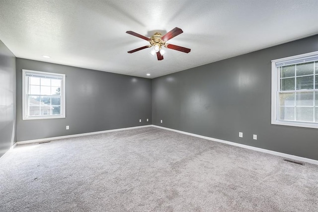 empty room featuring ceiling fan and carpet