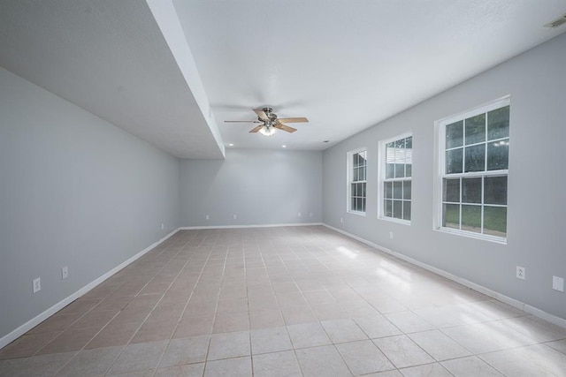 spare room featuring ceiling fan and light tile patterned floors