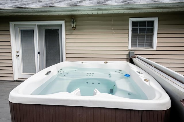 exterior space featuring a jacuzzi and wooden walls