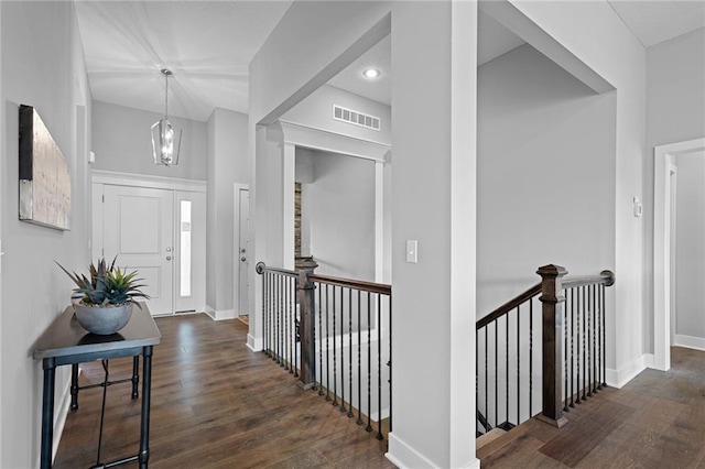 entrance foyer with a high ceiling, a notable chandelier, and dark hardwood / wood-style flooring