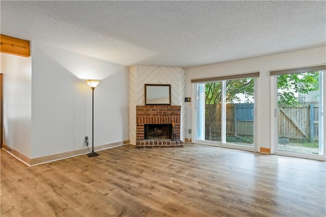 unfurnished living room featuring a textured ceiling, a fireplace, and light hardwood / wood-style floors