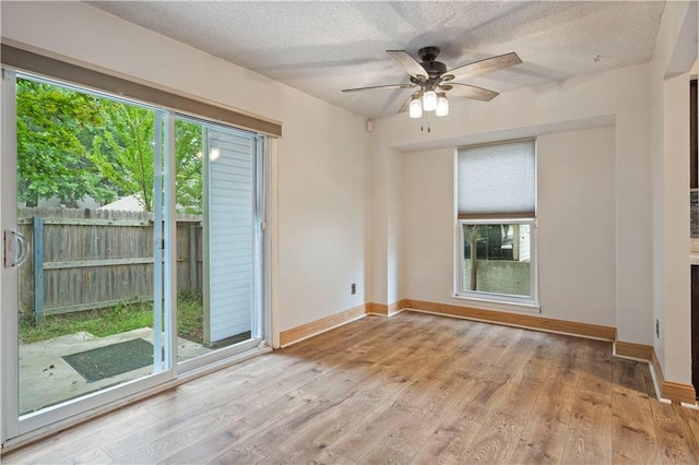 unfurnished room with ceiling fan, a textured ceiling, and light wood-type flooring