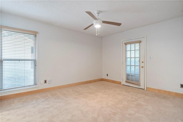 carpeted spare room with ceiling fan and a textured ceiling