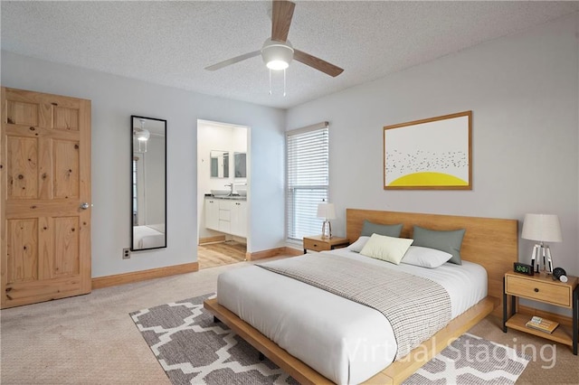 bedroom with light carpet, ensuite bath, a textured ceiling, and ceiling fan