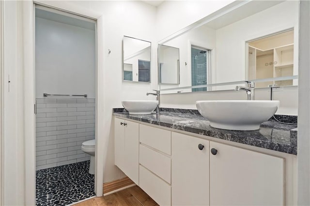 bathroom featuring walk in shower, hardwood / wood-style floors, vanity, and toilet