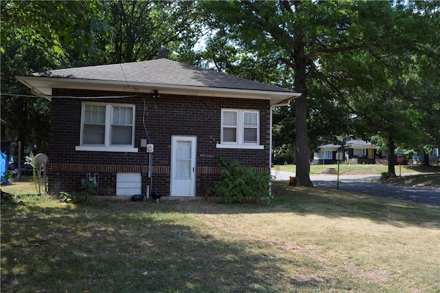 bungalow-style house featuring a front lawn and brick siding