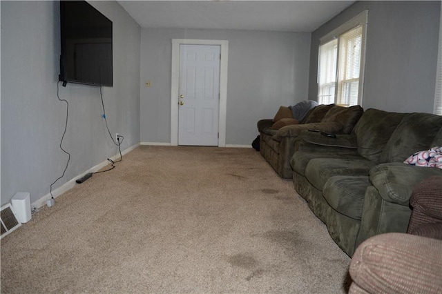 carpeted living area featuring visible vents and baseboards