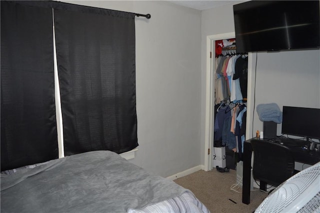 bedroom featuring carpet floors, a walk in closet, a closet, and baseboards