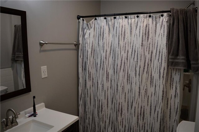 bathroom featuring vanity, toilet, and curtained shower