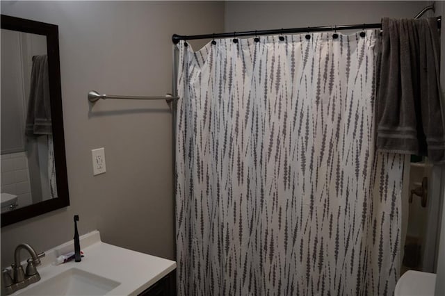 full bathroom featuring curtained shower, vanity, and toilet