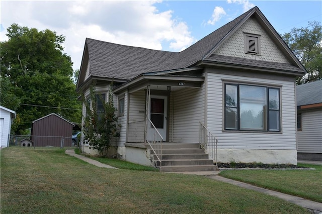 view of front of property featuring a front yard and an outbuilding