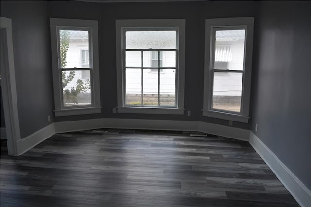 unfurnished room featuring dark wood-style floors and baseboards