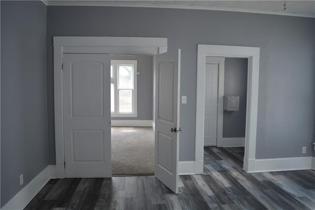 unfurnished bedroom featuring ornamental molding and dark hardwood / wood-style flooring