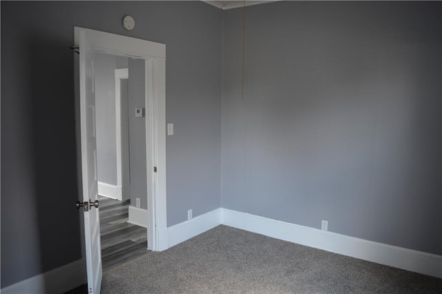 spare room featuring carpet floors and baseboards