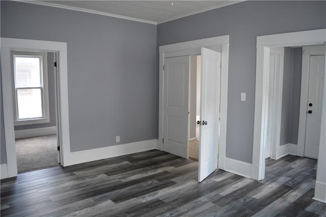 unfurnished bedroom featuring baseboards, dark wood-type flooring, and crown molding